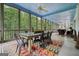 Inviting screened porch featuring a dining table and chairs, ideal for outdoor entertaining with views of the surrounding nature at 6017 Chestatee Creek Nw Ct, Acworth, GA 30101