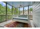 Charming screened porch with a hanging bed, perfect for relaxation and enjoying the outdoor scenery at 6017 Chestatee Creek Nw Ct, Acworth, GA 30101
