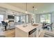 Open-concept kitchen and living area with modern lighting and a cozy fireplace at 4484 Eastbrook Pl # 54B, Snellville, GA 30039
