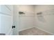 A walk-in closet with white walls and grey carpet, complete with shelving and hanging rods for storage at 4484 Eastbrook Pl # 54B, Snellville, GA 30039