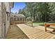 Large wooden deck overlooking the backyard, with a view of the screened in porch and gravel carport at 205 Shadowood Ln, Peachtree City, GA 30269