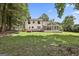Wide shot of backyard showing home exterior, deck, porch, and expansive yard at 205 Shadowood Ln, Peachtree City, GA 30269