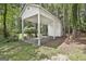 Covered carport nestled amongst the trees with gravel flooring and white support beams at 205 Shadowood Ln, Peachtree City, GA 30269