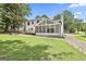 Lovely home exterior with a screened in porch and wooden deck overlooking a well-manicured backyard at 205 Shadowood Ln, Peachtree City, GA 30269
