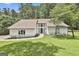 Inviting white home with a well-manicured lawn, complemented by mature trees and tasteful landscaping at 205 Shadowood Ln, Peachtree City, GA 30269