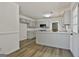 Open kitchen boasts neutral cabinets, stone countertops, stainless microwave, and wood flooring at 205 Shadowood Ln, Peachtree City, GA 30269