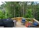 Deck features a grill, wicker furniture, and an overview of the wooded backyard at 302 Aspen Valley Ln, Dallas, GA 30157