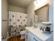 Cozy bathroom featuring a shower with curtain, white vanity and framed mirror at 302 Aspen Valley Ln, Dallas, GA 30157
