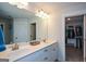 Well-lit bathroom vanity with double sinks, chrome fixtures, and a doorway to a walk-in closet at 302 Aspen Valley Ln, Dallas, GA 30157