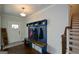 Bright foyer with a custom mudroom bench, dark hardwood floors, and stairs leading to the upper level at 302 Aspen Valley Ln, Dallas, GA 30157