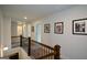 Second-floor hallway with iron and wood railing featuring Gathering photos and access to bedrooms and bathrooms at 302 Aspen Valley Ln, Dallas, GA 30157