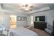 Spacious main bedroom with a tray ceiling, ceiling fan, and ensuite bathroom, and media center at 302 Aspen Valley Ln, Dallas, GA 30157