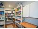 Well-organized pantry with white shelving, cabinets and wooden countertop at 302 Aspen Valley Ln, Dallas, GA 30157