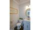 Elegant powder room featuring a marble countertop vanity, round mirror, decorative artwork, and modern fixtures at 302 Aspen Valley Ln, Dallas, GA 30157