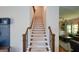 Bright staircase with carpeted treads, wood railing and iron balusters leading to the second floor of the home at 302 Aspen Valley Ln, Dallas, GA 30157