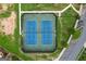 Aerial view of well-maintained tennis courts with blue playing surface and green surroundings at 302 Aspen Valley Ln, Dallas, GA 30157