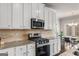 Kitchen with tile backsplash, stainless steel appliances, granite countertops, and dining area at 2829 Wild Laurel Ct, Norcross, GA 30071