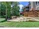 Landscaped backyard with a stone patio, fire pit, and stairs leading to the upper-level deck at 5245 Cottage Farm Rd, Johns Creek, GA 30022