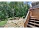 Outdoor patio featuring a built-in stone fire pit and landscaped backyard at 5245 Cottage Farm Rd, Johns Creek, GA 30022