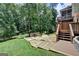 Beautifully landscaped backyard with a stone patio, built-in seating, and fire pit at 5245 Cottage Farm Rd, Johns Creek, GA 30022