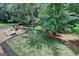 Well-maintained backyard featuring a stone patio with built-in seating and lush greenery at 5245 Cottage Farm Rd, Johns Creek, GA 30022