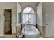 Bathroom featuring a large soaking tub, a window with natural light, and tiled shower with glass door at 5245 Cottage Farm Rd, Johns Creek, GA 30022