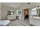 Bright bathroom featuring dual vanities, a soaking tub, and an open doorway to the bedroom at 5245 Cottage Farm Rd, Johns Creek, GA 30022