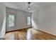 A bright bedroom with hardwood floors and windows overlooking a green, wooded area at 5245 Cottage Farm Rd, Johns Creek, GA 30022