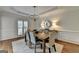 Open dining room is bathed in natural light, featuring a wooden table, chandelier and hardwood floors at 5245 Cottage Farm Rd, Johns Creek, GA 30022
