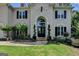 Arched front door entrance with manicured landscaping and traditional black shutters at 5245 Cottage Farm Rd, Johns Creek, GA 30022
