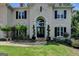 Arched front door entrance with manicured landscaping and traditional black shutters at 5245 Cottage Farm Rd, Johns Creek, GA 30022