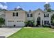 Elegant home featuring a manicured lawn, a large arched front door, and a three car garage at 5245 Cottage Farm Rd, Johns Creek, GA 30022