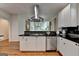 Kitchen featuring white cabinets, stainless steel appliances, black countertops, and wood floors at 5245 Cottage Farm Rd, Johns Creek, GA 30022
