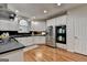 Bright kitchen featuring white cabinets, stainless steel appliances, black countertops, and wood floors at 5245 Cottage Farm Rd, Johns Creek, GA 30022