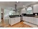 Bright kitchen featuring white cabinets, stainless steel appliances, black countertops, and wood floors at 5245 Cottage Farm Rd, Johns Creek, GA 30022