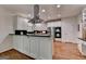 Bright kitchen featuring white cabinets, stainless steel appliances, and a large island with black countertop on wood floor at 5245 Cottage Farm Rd, Johns Creek, GA 30022