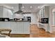 Bright kitchen featuring white cabinets, stainless steel appliances, and a large island with black countertop on wood floor at 5245 Cottage Farm Rd, Johns Creek, GA 30022