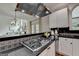 Kitchen featuring a gas cooktop, black countertops, stainless steel dishwasher, and a view into the adjacent living space at 5245 Cottage Farm Rd, Johns Creek, GA 30022