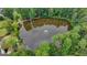 Aerial shot of a tranquil pond with a fountain, surrounded by lush greenery and trees, offering a peaceful escape at 5245 Cottage Farm Rd, Johns Creek, GA 30022