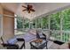 Inviting screened porch with wicker furniture, ceiling fan and wooded view at 5245 Cottage Farm Rd, Johns Creek, GA 30022