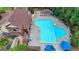 An aerial view of a large community swimming pool surrounded by lounge chairs and blue umbrellas at 5245 Cottage Farm Rd, Johns Creek, GA 30022