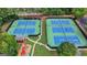 Aerial view of tennis courts and playground nestled amongst mature trees, offering opportunities for outdoor fun at 5245 Cottage Farm Rd, Johns Creek, GA 30022