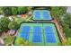 Aerial view of well-maintained tennis courts, surrounded by greenery, offering a private and serene playing experience at 5245 Cottage Farm Rd, Johns Creek, GA 30022