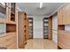 Spacious walk-in closet with custom shelving, hanging rods, and wood flooring at 5245 Cottage Farm Rd, Johns Creek, GA 30022
