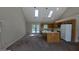 Open kitchen featuring a center island, white appliances, and vaulted ceiling with skylights at 9230 Melody Sw Cir, Covington, GA 30014