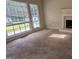 Bright living room featuring large windows, neutral carpet, fireplace and decorative mantel at 9230 Melody Sw Cir, Covington, GA 30014