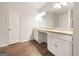 Bright bathroom with double sink vanity, modern lighting, white cabinetry, and wood-look vinyl flooring at 36 Crescent Chase, Dallas, GA 30157