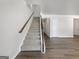 Carpeted staircase with wood railing connecting the home's levels at 36 Crescent Chase, Dallas, GA 30157