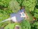 An aerial view showcases the home's secluded backyard with pool, spa, patio, and lush landscaping and mature trees at 750 Crest Valley Nw Dr, Sandy Springs, GA 30327