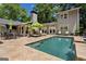 Backyard with pool, patio, lush trees, furniture, and manicured lawn at 750 Crest Valley Nw Dr, Sandy Springs, GA 30327